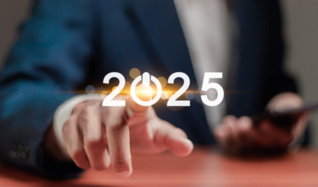 An image of a man pressing the “0” in 2025, lighting it up and activating his business for the new year and their 2025 business goals.