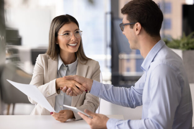 Business partners shaking hands after reached agreement in office